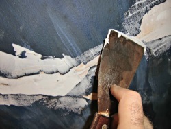 smoothing-the-caulk-with-a-wet-putty-knife-for-plaster-ceiling-repair