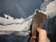 smoothing-the-caulk-with-a-wet-putty-knife-for-plaster-ceiling-repair