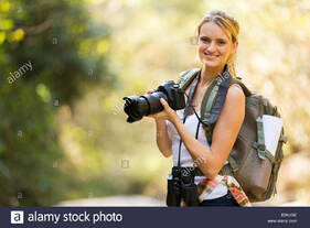 young woman holding a dslr camera in mountain valley Stock Photo - Alamy