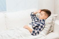 Ill boy lying in bed and suffering from headache Stock Photo by ©Syda_Productions 92520110