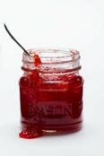 A jar of strawberry jam on a white … – License Images – 11987336 ❘ StockFood