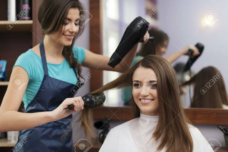 Female Hairdresser Using Hairbrush And Hair Dryer Stock Photo, Picture And Royalty Free Image. Image 25931259.