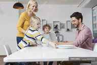 Family laying the table with father using laptop — connection, Two Parents - Stock Photo | #180247162
